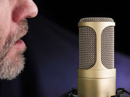 golden broadcast voice microphone on dark background - closeup shotの写真素材