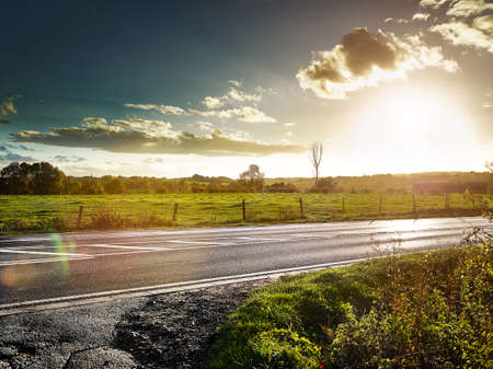 country road at sundown, cloudy backlite shot  peferct for car copy spaceの写真素材