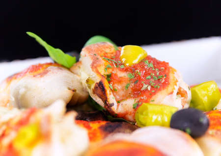 Variantion of pizza Mini pizza - with herbs pesto, chicken, chilli, peppers, olives and tomatoes. Mini pizza and pizza rolls Calsone pizza breadの写真素材