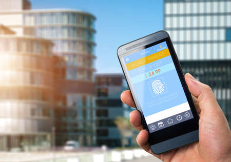 Mobile Payment,  smart pay - man holding a phone with contactless pay wallet app for smart shoppingの写真素材