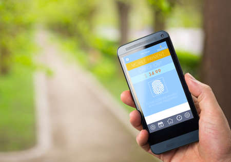 Mobile Payment,  smart pay - man holding a phone with contactless pay wallet app for smart shoppingの写真素材