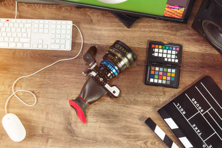 Desktop shot of a modern Digital Cinema Camera and clapboard on stylish wooden desktop Workplace Backgroundの写真素材