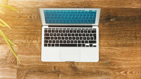 Laptop on Vintage Wooden desktop in modern office with accessoires - top view on desk from aboveの写真素材