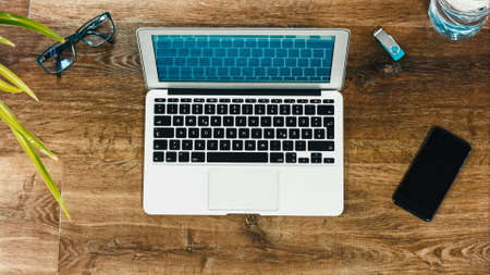 Laptop on Vintage Wooden desktop in modern office with accessoires - top view on desk from aboveの写真素材