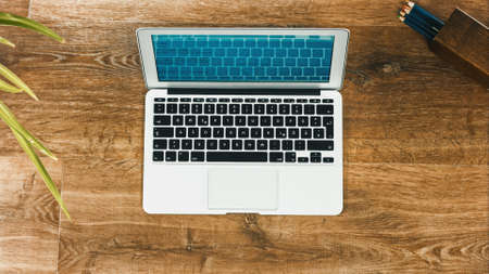Laptop on Vintage Wooden desktop in modern office with accessoires - top view on desk from aboveの写真素材
