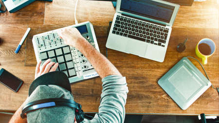 Music Producer DJ working with his drum machine mixer - overhead shot top