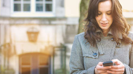 Businesswoman use her mobile phone outdoor in a historic villageの写真素材
