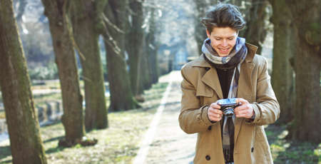 Attractive Tourist taking a photograph with vintage camera of Historic old village / town at sunsetの写真素材