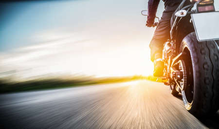 motorbike on the road riding. having fun driving the empty road on a motorycle tour journey. copyspace for your individual text.の写真素材