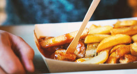French fries on tracing paper on board on wooden tableの写真素材