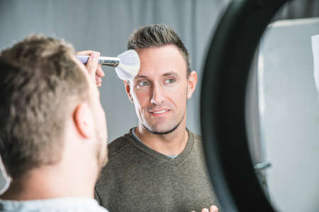 makeup artist working on models face in shooting break on movie set locationの写真素材