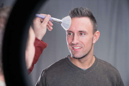 makeup artist working on models face in shooting break on movie set locationの写真素材