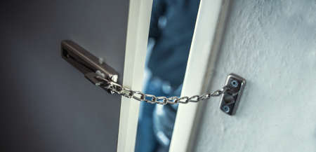masked burglar with crowbar breaking and entering into a victim's homeの写真素材