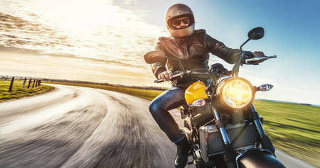motorbike on the road riding. having fun driving the empty road on a motorcycle tour journey. copyspace for your individual text.の写真素材