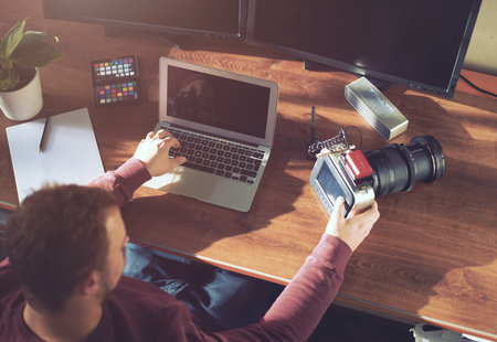 Creative young man his office / agency working with movie camera - analog film look