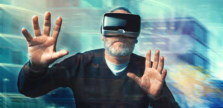 Mature business man wearing virtual reality goggles / VR Glasses to work with in modern officeの写真素材
