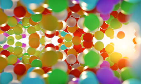 colorful bouncing balls outdoors against blue sunny skyの写真素材