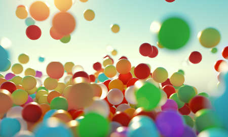 colorful bouncing balls outdoors against blue sunny skyの写真素材