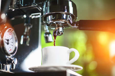 Espresso pouring from classic coffee machine into small white cup. Close-up Shot.の写真素材