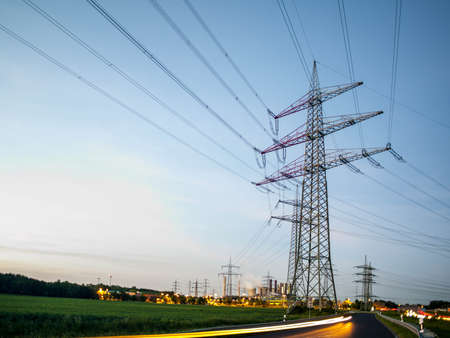 electricity pylons at sunset transporting clean renewable energyの写真素材