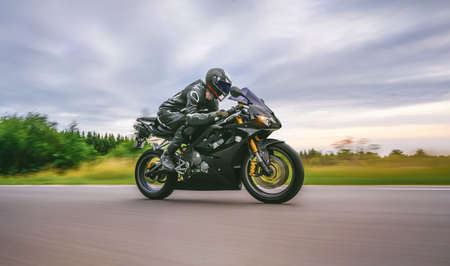 motorbike on the forest road riding. having fun driving the empty road on a motorcycle tour journey. copyspace for your individual text.の写真素材