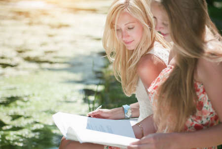 two student gilrs are study outside in the parkの写真素材