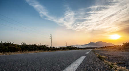 Empty long road on a sunny summer day at bright sunsetの写真素材