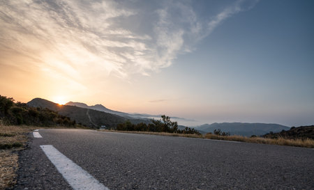 Empty long road on a sunny summer day at bright sunset