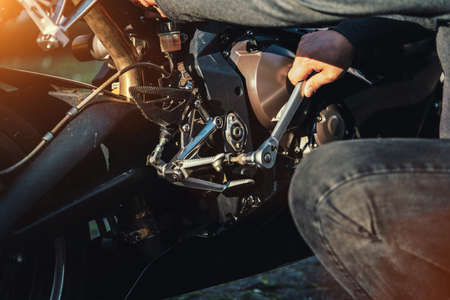 Mechanic working on Motocycle in mechanics garage. Repair service. authentic close-up shotの写真素材