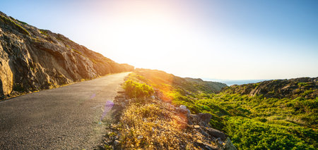 Mediterranean sea coast road into mountains horizon in summer with beautiful bright sun rays - wide...