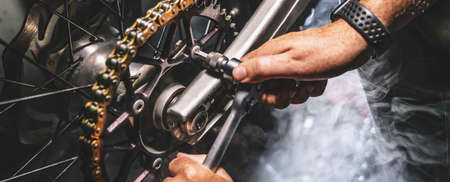 Mechanic working on Motocycle in mechanics garage. Repair service. authentic close-up shotの写真素材