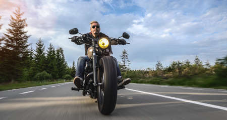 motorbike on the forest road riding. having fun driving the empty road on a motorcycle tour journey. copyspace for your individual text.の写真素材