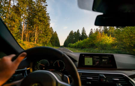 hands of car driver on steering wheel, road trip, driving on highway roadの写真素材