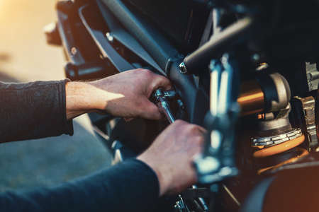 Mechanic working on Motocycle in mechanics garage. Repair service. authentic close-up shotの写真素材