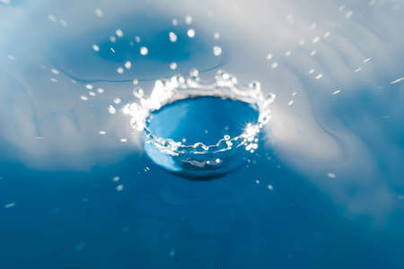 water drop falling in water の写真素材