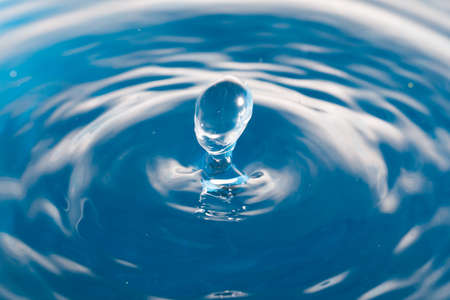 Water drop falling into waterの写真素材