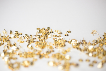 Gold tack confetti on white backgroundの写真素材