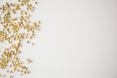 Gold tack confetti on white backgroundの写真素材