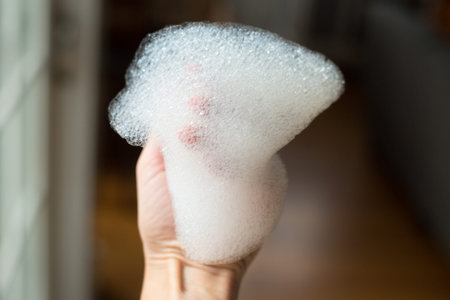 White foamy suds around a hand.