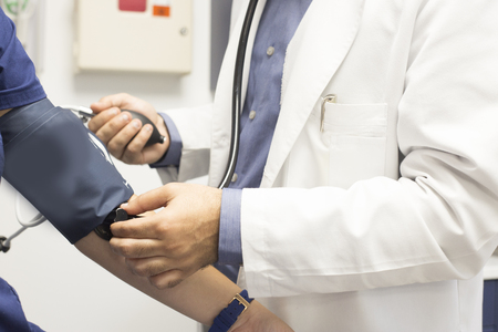 A medical doctor takes a patient's blood pressure.の写真素材