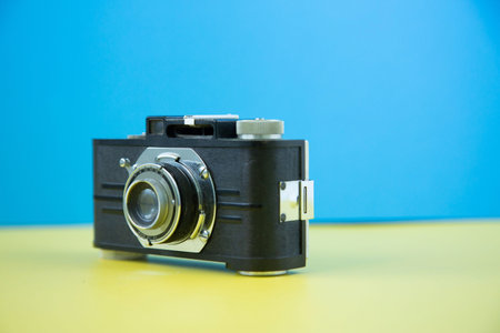 A retro vintage camera shot on a colorful background with selective focus.の写真素材