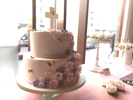 A beautiful 2 tier first communion cake on a table.の写真素材