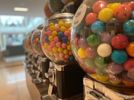Rows of colorful candy machines in a mallの写真素材