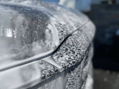 A truck with soapy suds all over it on a sunny day.の写真素材