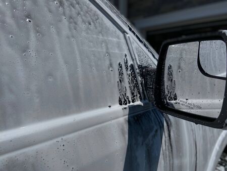 A truck with soapy suds all over it on a sunny day.の写真素材
