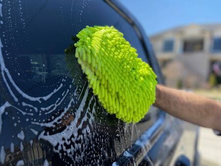 A man washes his truck with a green soft sponge.の写真素材
