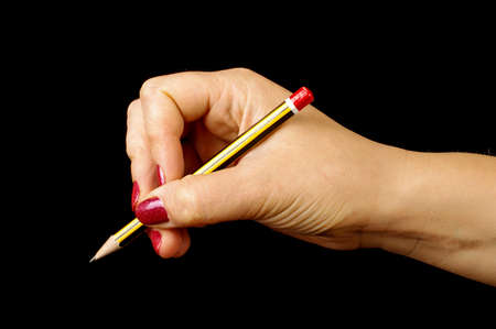 Woman hand holding pencil on the black backgroundの写真素材
