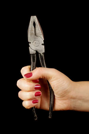 Woman hand squeezing pliers isolated on the blackの写真素材