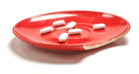 Bite off plate with white pills on the white backgroundの写真素材