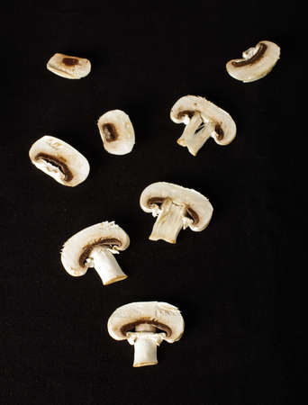 Raw champignon mushroom slices on the dark backgroundの写真素材
